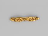 a close up of a gold hair clip on a gray surface