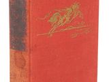 an old book with a red cover and gold writing
