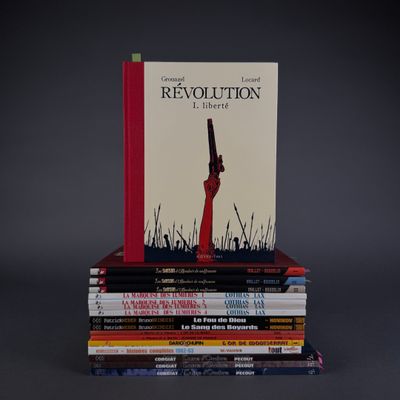 books stacked on top of each other with a gun on top of them