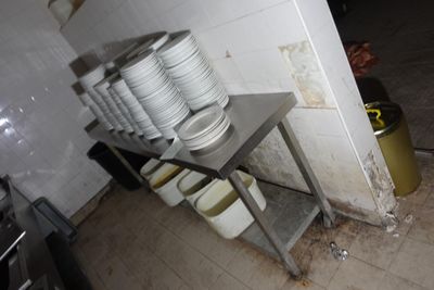 de nombreuses assiettes empilées sur une étagère métallique dans la cuisine