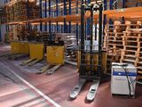 a forklift in a warehouse with pallets and pallets