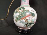 a vase with a peacock on it sitting on a table