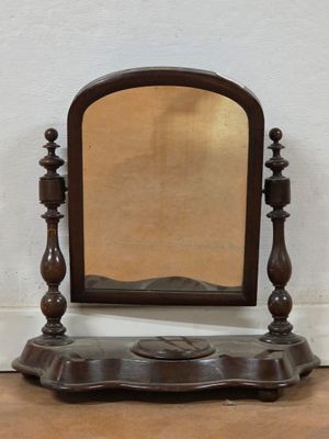 a mirror sitting on top of a table next to a wall