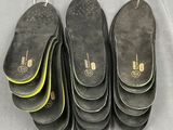 six pairs of black and yellow shoes are lined up on a table
