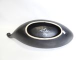 a black bowl with a white rim on a white surface
