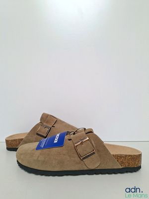 un gros plan sur une paire de sandales posées sur une surface blanche
