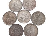 six pièces d'argent sont disposées en cercle sur un fond blanc