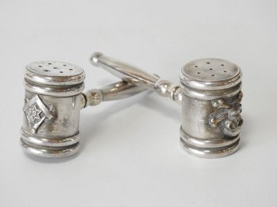 pair of silver salt and pepper shakers on a white surface