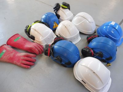 many hard hats and gloves laid out on the floor