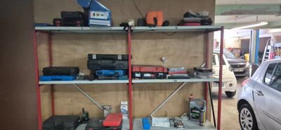 une voiture garée dans un garage, à côté d'une étagère sur laquelle sont posés divers objets