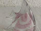 a glass sculpture of a pink and white swirl on a table
