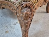 a close up of a chair with a floral upholstered seat