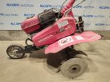 a pink lawn mower that is sitting on the ground