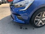 the front end of a blue car parked on the side of the road