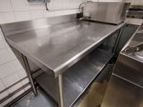une grande cuisine en inox équipée d'un évier et d'une cuisinière