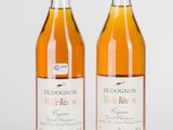 deux bouteilles de vin posées l'une à côté de l'autre sur une surface blanche