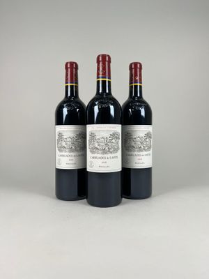 trois bouteilles de vin rouge posées côte à côte sur une table