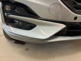 the front end of a white car with a denting bumper