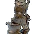 a statue of a man sitting on a toilet with a bird on top of it