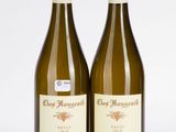 deux bouteilles de vin posées l'une à côté de l'autre sur une surface blanche