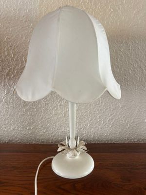 a white lamp that is sitting on a wooden table
