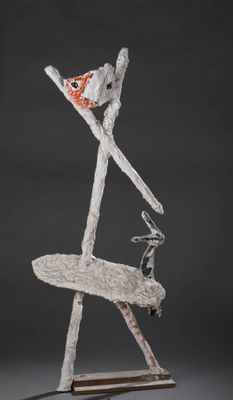 une photo représentant une sculpture d'une personne à skis posée sur un socle en bois