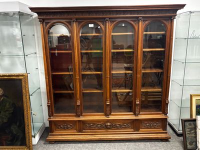 une vitrine sur laquelle est accrochée une peinture, dans une pièce