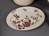 a plate with a floral design on it next to a stack of plates