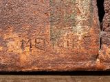 an old rusted brick with a hole in the middle of it with a word written on it