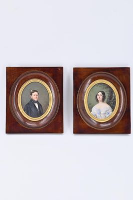 deux portraits encadrés représentant un homme et une femme, accrochés au mur