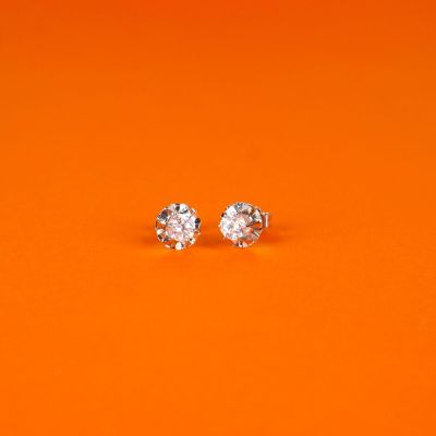 une paire de boucles d'oreilles en diamant sur fond orange