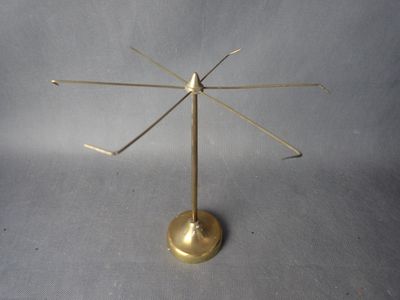 une petite plaque en laiton sur laquelle repose un petit objet métallique