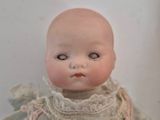 a small doll that is sitting on a white surface