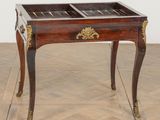 a small table with a glass top on a wooden floor