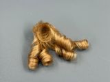 two pieces of blonde hair on a gray surface