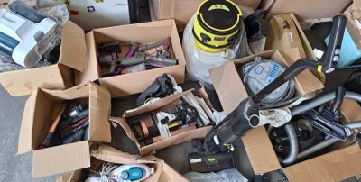 un tas d'objets divers rangés dans des cartons posés par terre