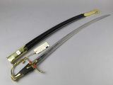 two swords with a gold handle and a black handle