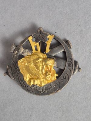 une photo d'une broche en or et en argent sur laquelle est représenté un lion