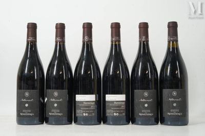 six bottles of wine are lined up in a row on a table