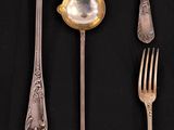 several spoons, forks, and spoon rest on a black surface