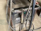 a machine that is sitting in the garage with a hose