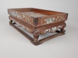 a small wooden tray with flowers on it on a table