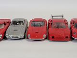 five red cars lined up in a row on a white surface