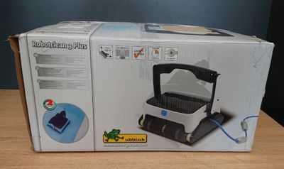 une boîte contenant un aspirateur, posée sur une table en bois