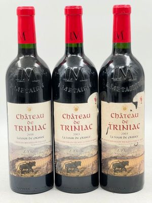 trois bouteilles de vin rouge posées l'une à côté de l'autre sur une surface blanche