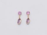 une paire de boucles d'oreilles ornées de pierres violettes sur fond blanc