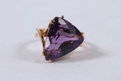 gros plan d'un anneau de pierre violette sur une surface blanche