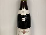 une bouteille de vin posée sur une table à côté d'un verre de vin