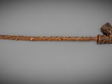 an old wooden stick with a carved handle on a gray background