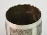 a silver cup that is sitting on a table
